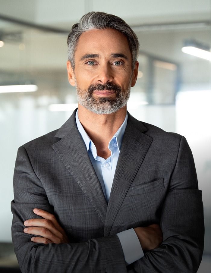 Confident businessman with gray hair and beard.