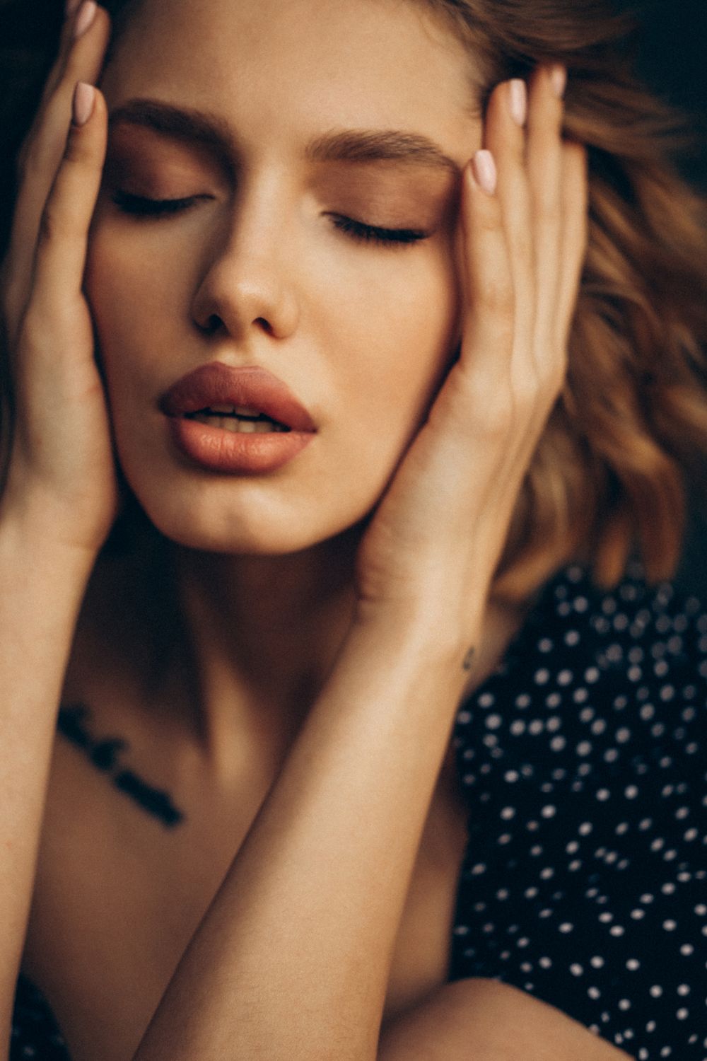 Portrait of a woman with hands on face.